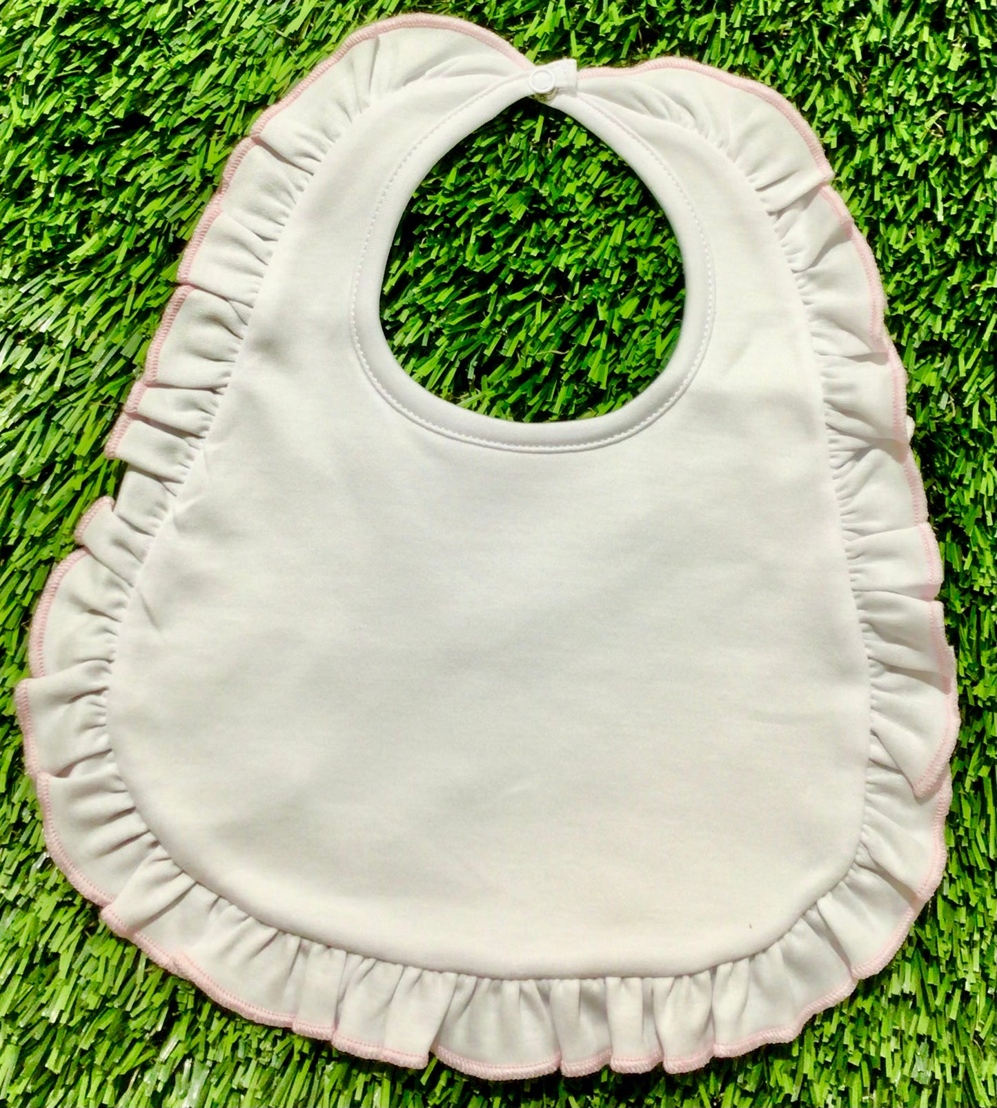 Essentials white bib with pink ruffle